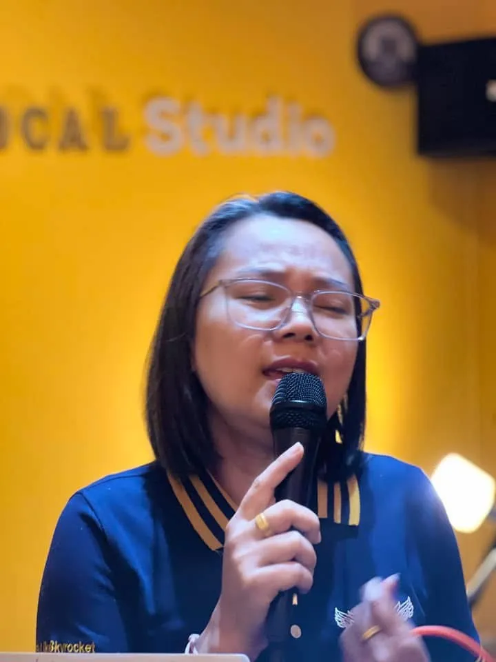 นักเรียนผู้ใหญ่ฝึกร้องเพลงหน้าผนังสตูดิโอ