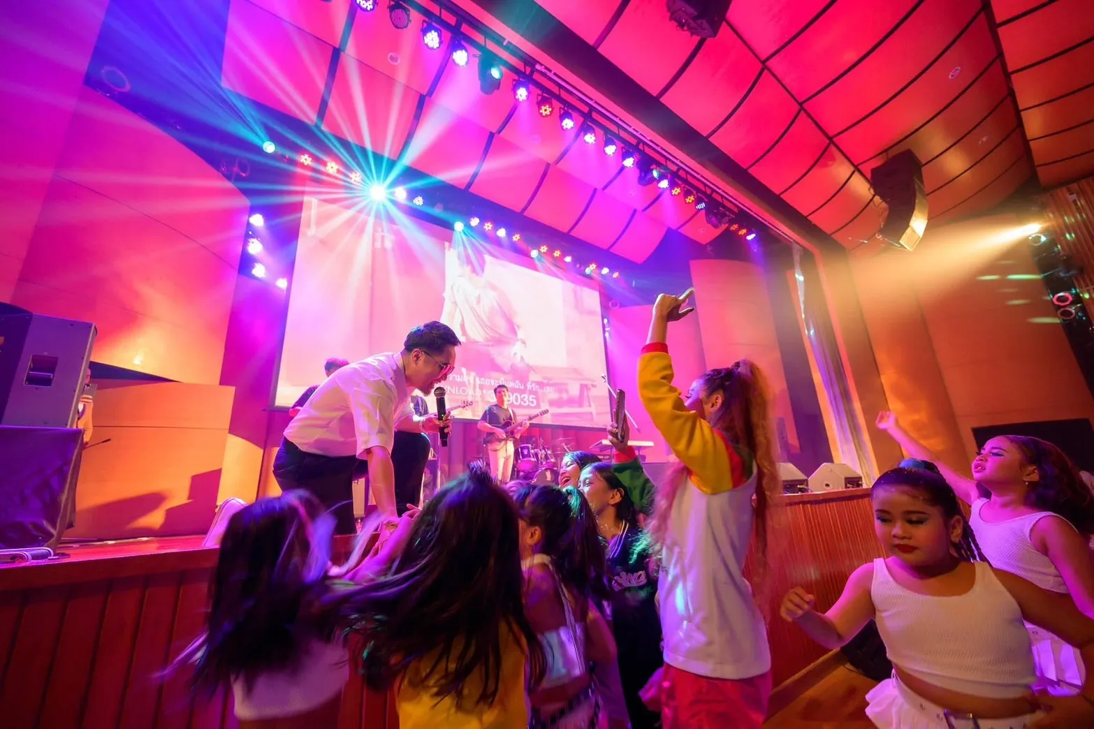 นักเรียนเต้นและร้องเพลงบนเวทีคอนเสิร์ตของโรงเรียน