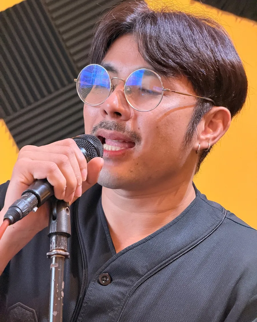 นักเรียนร้องเพลงกับไมโครโฟนในห้องเรียนของครูโป