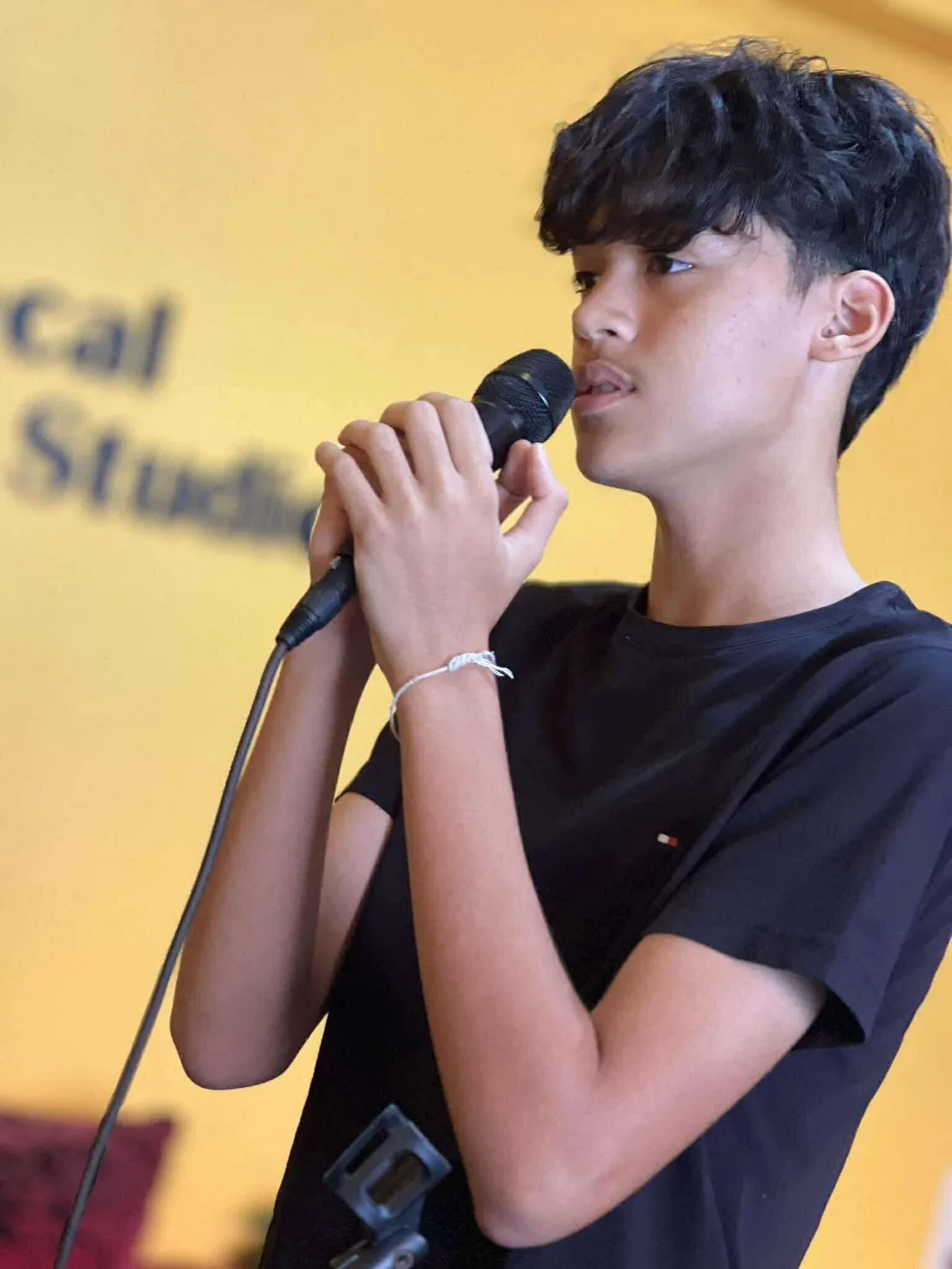 นักเรียนวัยรุ่นฝึกร้องเพลงหน้าผนัง Vocal Studio
